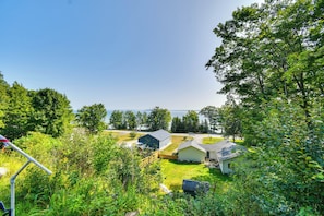 A residential area with houses, a grassy yard, and a view of the water. - New Home on Lake Michigan's Traverse City West Bay (Traverse City)