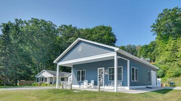 A single-story house with a covered porch, a small detached garage, and a well-maintained lawn.