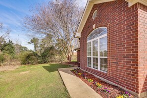 A brick house with a large window, a concrete pathway, and a flower bed. - Close to Hospitals! Family Gem in West Monroe (West Monroe)