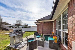 An outdoor patio with a grill, wicker furniture, and a view of a brick building. - Close to Hospitals! Family Gem in West Monroe (West Monroe)