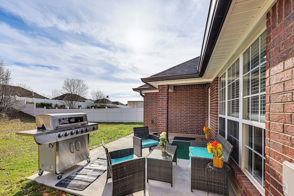 An outdoor patio with a grill, wicker furniture, and a view of a brick building. - Close to Hospitals! Family Gem in West Monroe (West Monroe)