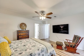 A bedroom with a bed, dresser, chair, ceiling fan, and a door leading to another room. - Close to Hospitals! Family Gem in West Monroe (West Monroe)