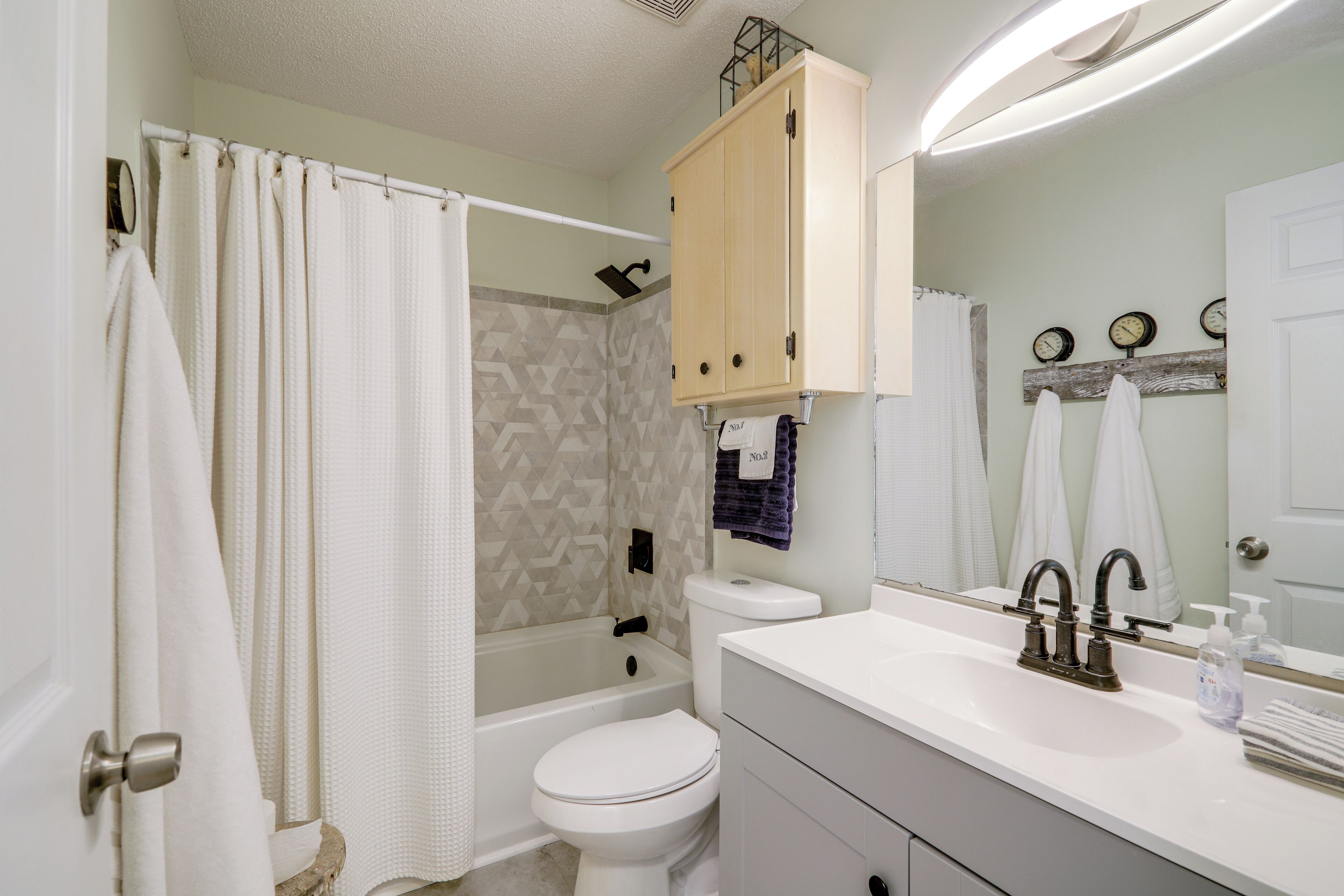 A bathroom with a bathtub, toilet, and sink.