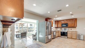 A spacious kitchen with granite countertops, stainless steel appliances, and wooden cabinets. - Fish, Paddle & Explore: Crystal River Gem w/ Dock (Crystal River)