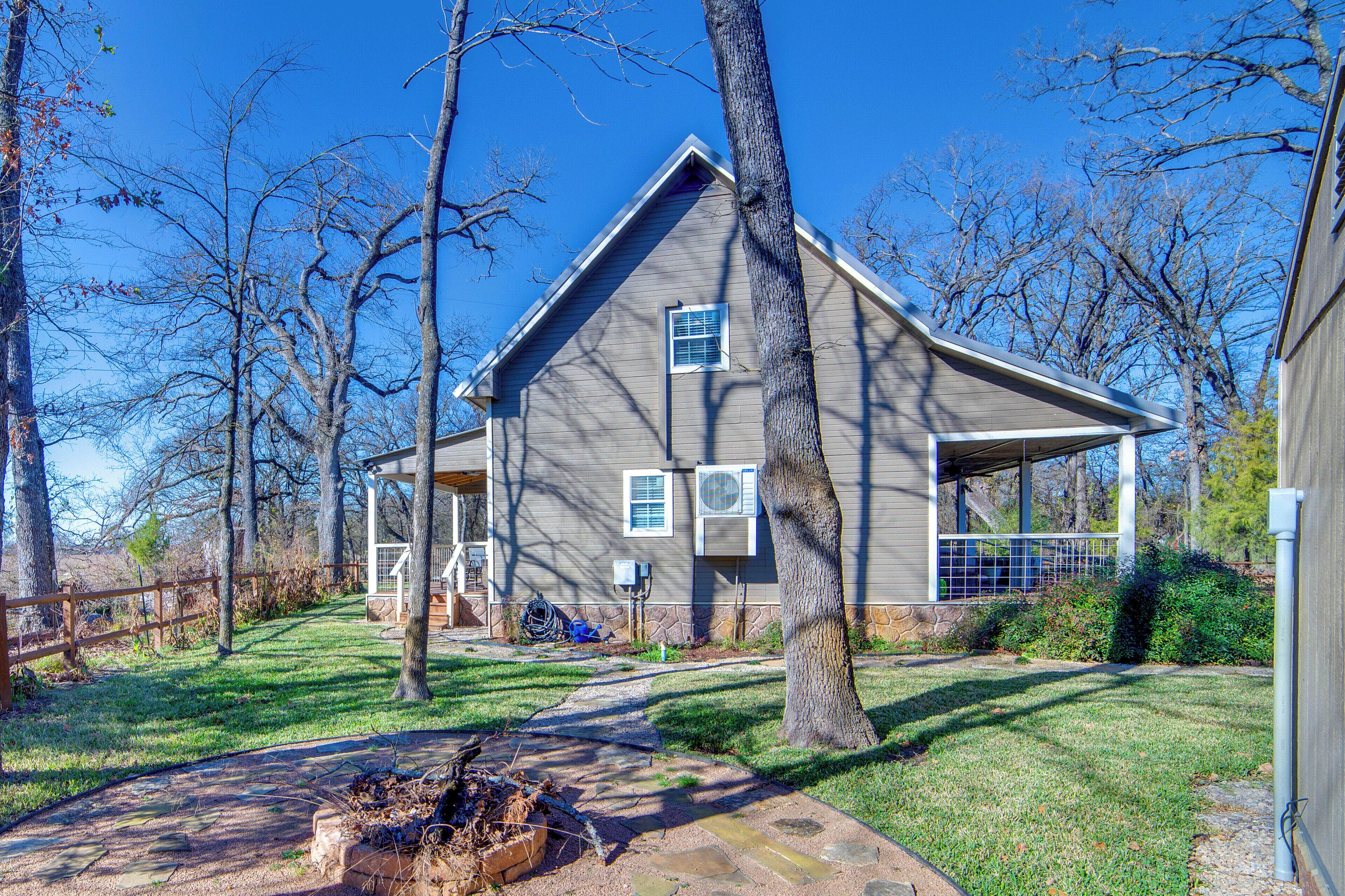 A two-story house with a sloped roof, a covered porch, and a stone pathway leading to the front door.