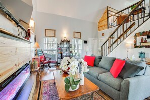 A spacious living room with a grey sofa, red cushions, a wooden coffee table, and a staircase with a wooden railing. - Anglers' Haven! Cedar Creek Reservoir Getaway (Kemp)