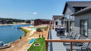 A waterfront property with a deck, outdoor seating, and a view of the water.