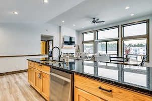 Una cocina moderna con una isla grande, armarios de madera y un lavavajillas integrado.