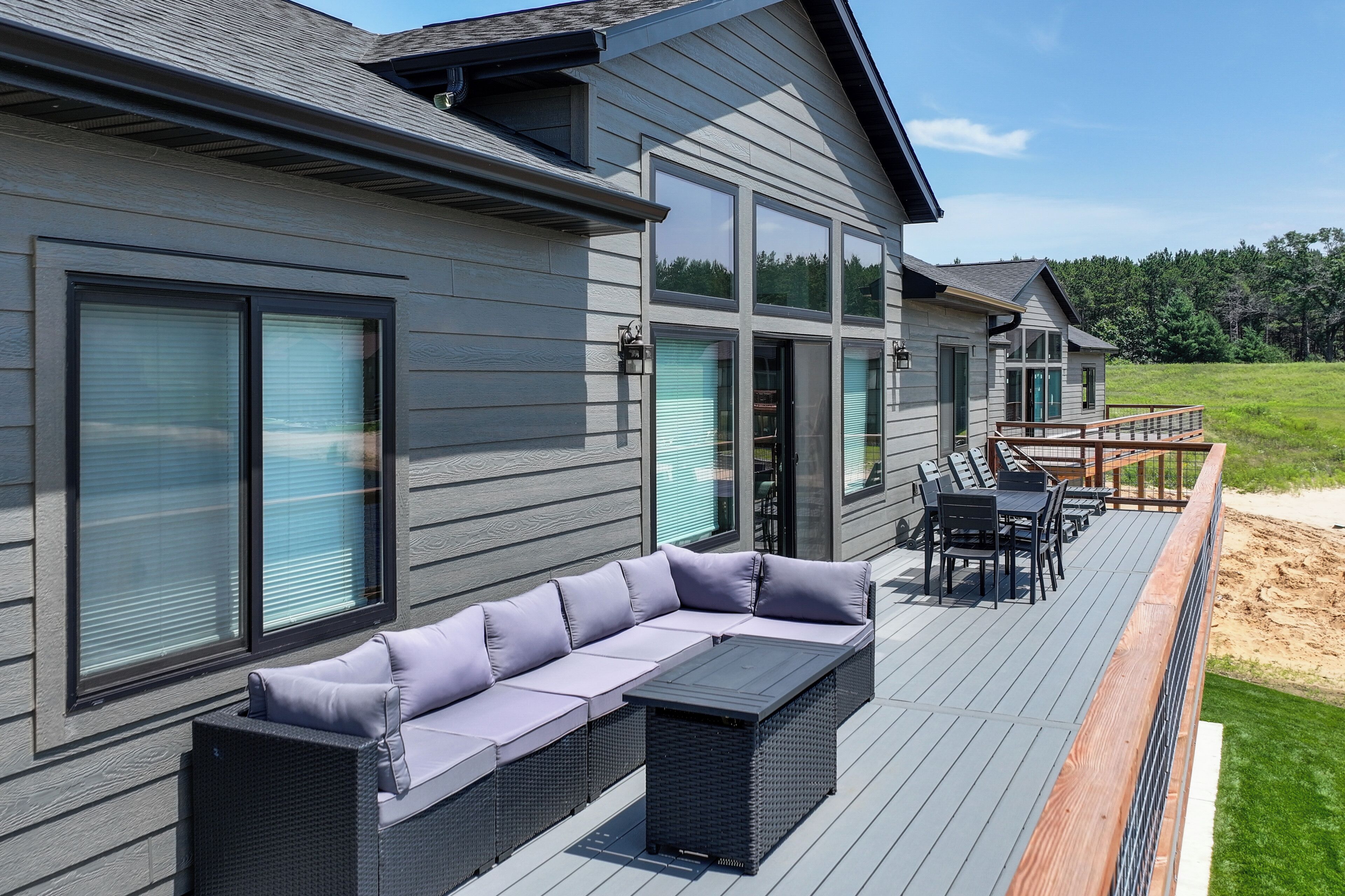 A modern house with a deck, a sofa, and a table.