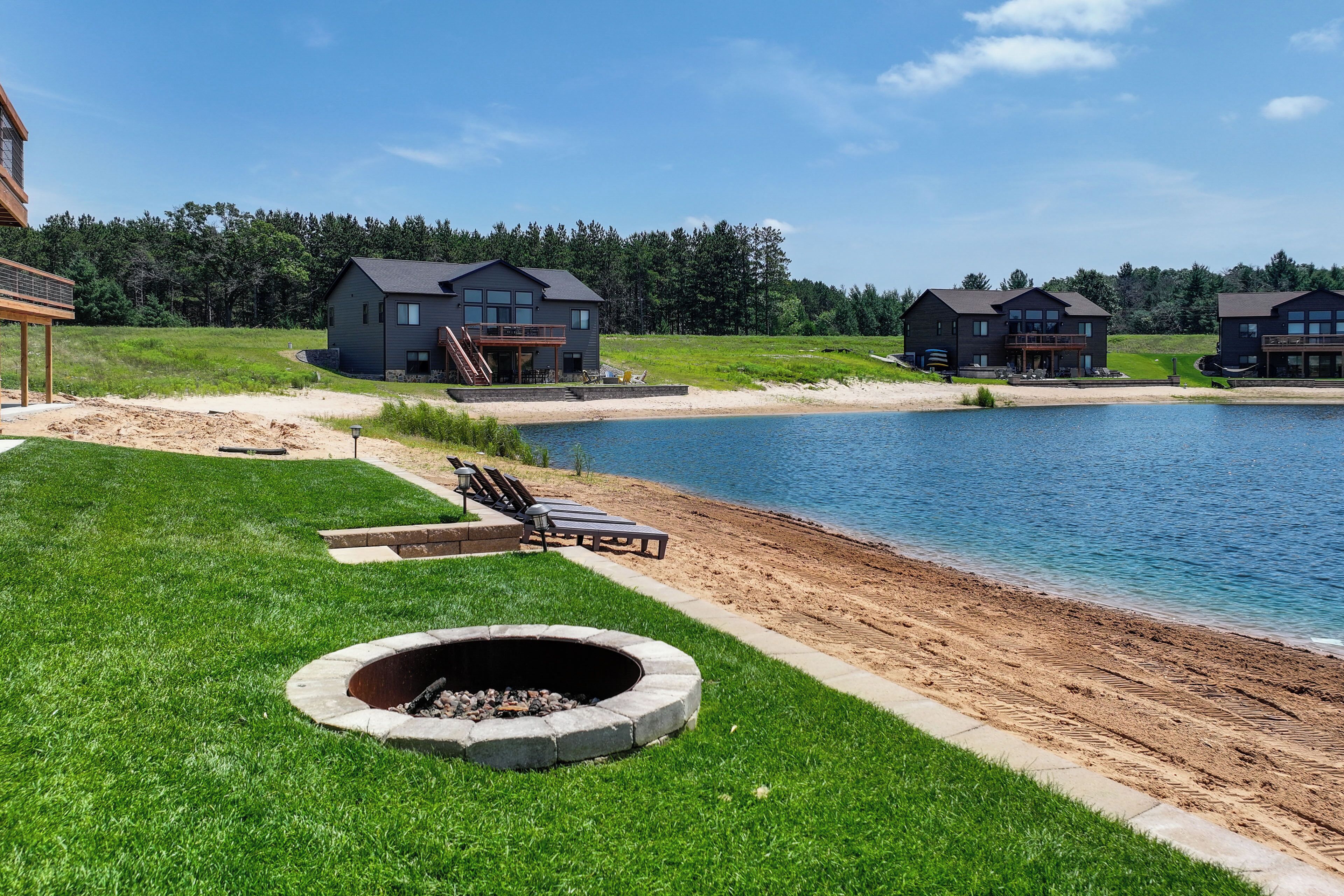 Propiedad junto al lago con fogata, sillas de descanso y zona para nadar.
