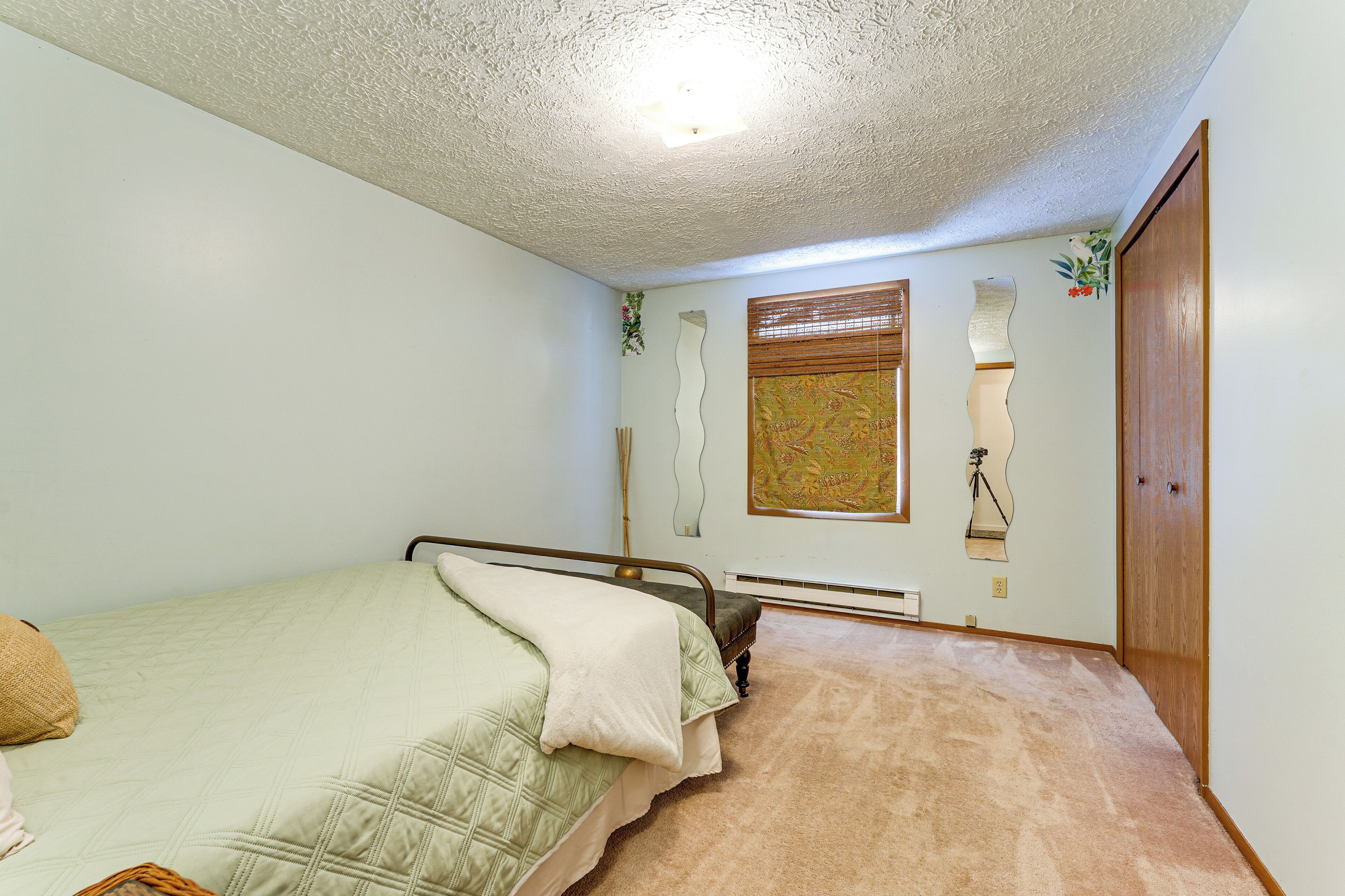 Un dormitorio con cama, puerta de madera y radiador.