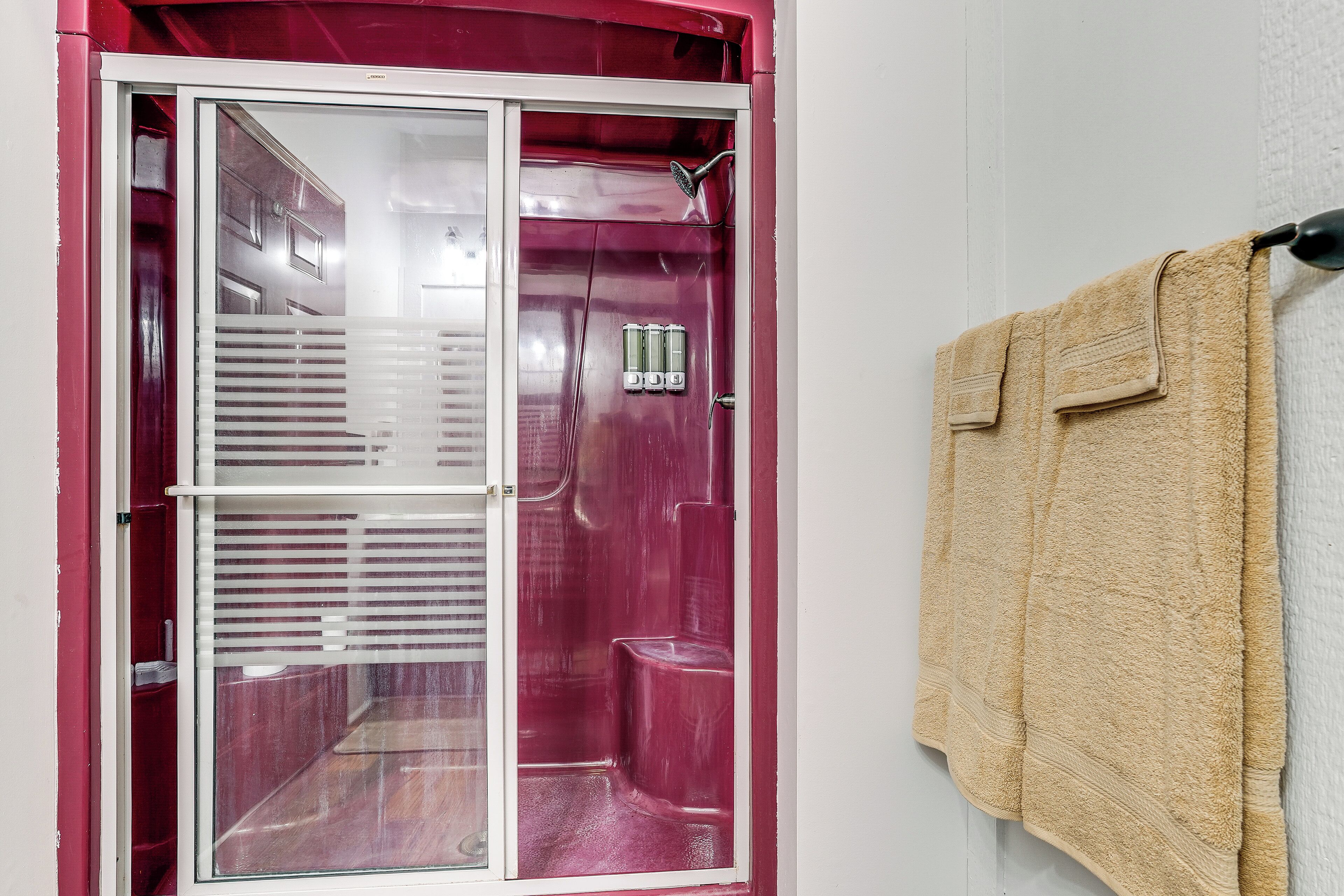 Ein Badezimmer mit Duschkabine, Handtuchhalter und Toilette.