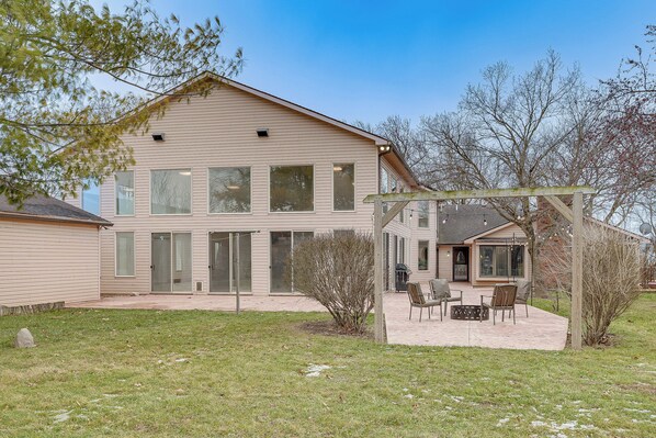 A two-story house with a patio area featuring outdoor furniture. - Woodburn Group Getaway: Endless On-site Fun! (Harlan)