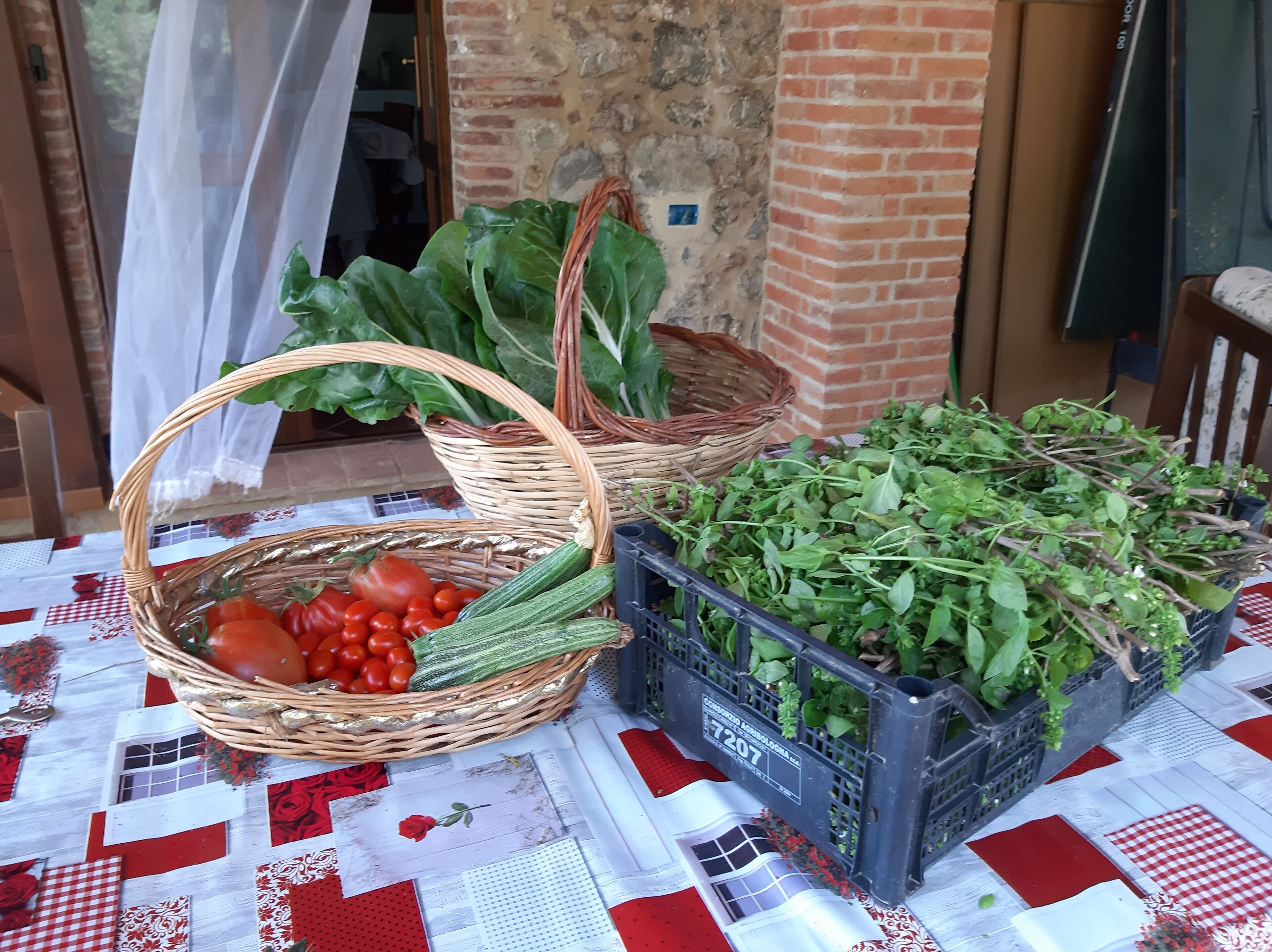 Taula amb cistelles i caixes de verdures fresques.