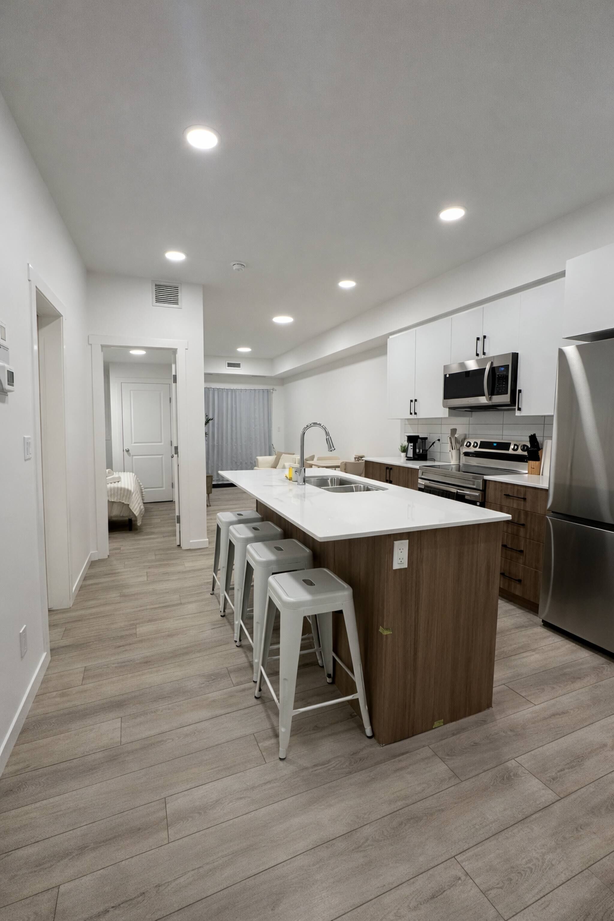 A modern kitchen with a central island, stainless steel appliances, and a walk-in closet.