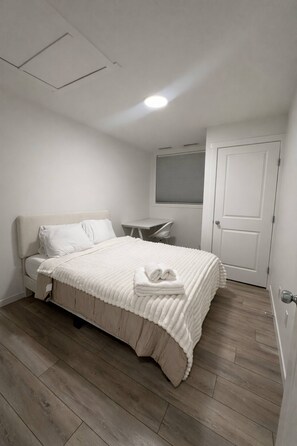 Une chambre à coucher avec un lit, un bureau et une porte.