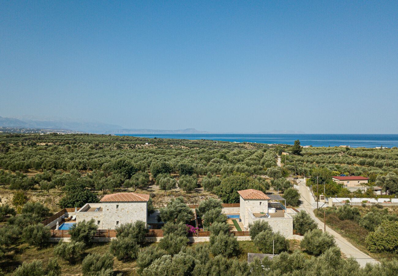 A coastal property with stone buildings, a swimming pool, and a view of the sea.