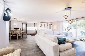 Una sala de estar moderna con sofá, comedor y cocina.