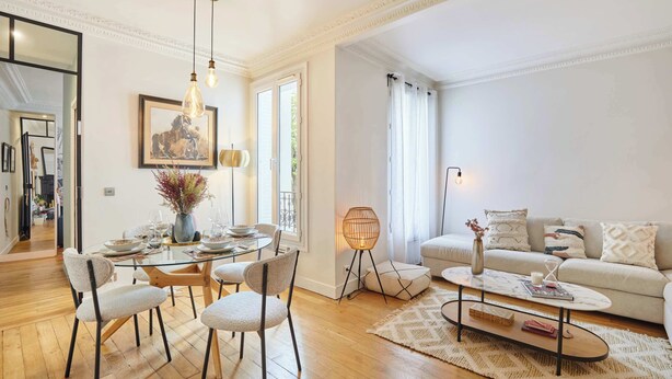 A modern living room with a glass dining table, comfortable seating, a sofa, and a coffee table. - Superb apartment Invalides Eiffel Tower (Paris)