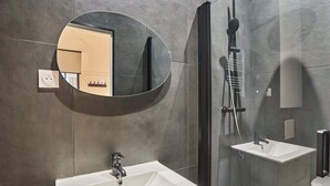 A modern bathroom with a round mirror, a sink, and a shower enclosure. - Wonderful Apartment Center of Paris-Montorgueil (Paris)