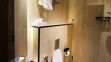 A modern bathroom with a marble sink, a toilet, and a shower.