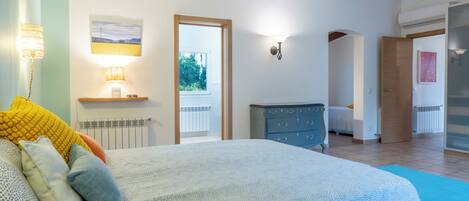 Un dormitorio con cama, lámparas de noche, cómoda y vistas al exterior.