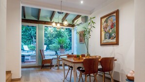 A dining area with a wooden table, chairs, and a potted plant. - El Jardin de Lara, Casa con Parking Son Españolet-palma (Palma de Mallorca)
