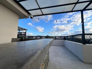 A rooftop terrace with a concrete bar, a metal roof, and a view of the sky. - Exquisite Boho Sunset luxury Suite, Jacuzzi + 2Bed (Flic en Flac)