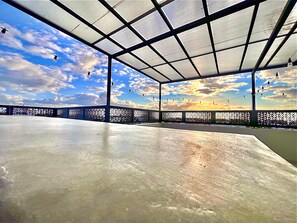 An indoor space with a view of the sky through a patterned ceiling, a concrete floor, and a decorative fence. - Exquisite Boho Sunset luxury Suite, Jacuzzi + 2Bed (Flic en Flac)