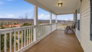 A covered porch with a view of a landscape, including trees and distant hills. - Heishman Historic Hillside Home 4 Bedroom Home (Wardensville)