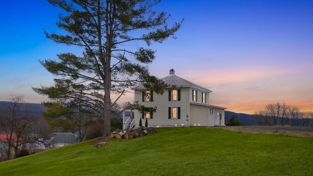 A two-story house with a large lawn in front, surrounded by trees and a clear sky. - Heishman Historic Hillside Home 4 Bedroom Home (Wardensville)