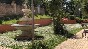 A garden with a fountain, brick walls, and potted plants. - Paradiso Country house (Pescara)