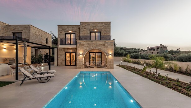 Une maison moderne dotée d’une piscine, d’un espace salon extérieur et offrant une vue sur le paysage environnant.