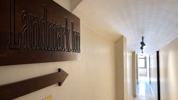 A hallway with a sign reading "Landmark Inn" and a directional arrow pointing to the right. - Landmark Inn (Lanka)