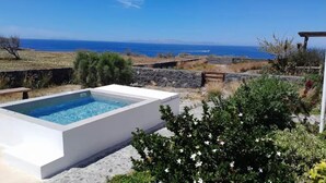 Ein rechteckiger Pool mit glasklarer, blauer Wasseroberfläche, umgeben von einer weißen Poolterrasse.