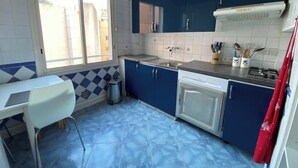 A kitchen with blue cabinets, a white countertop, and a window. - 2 rooms 8 av de l'ilette (Antibes)