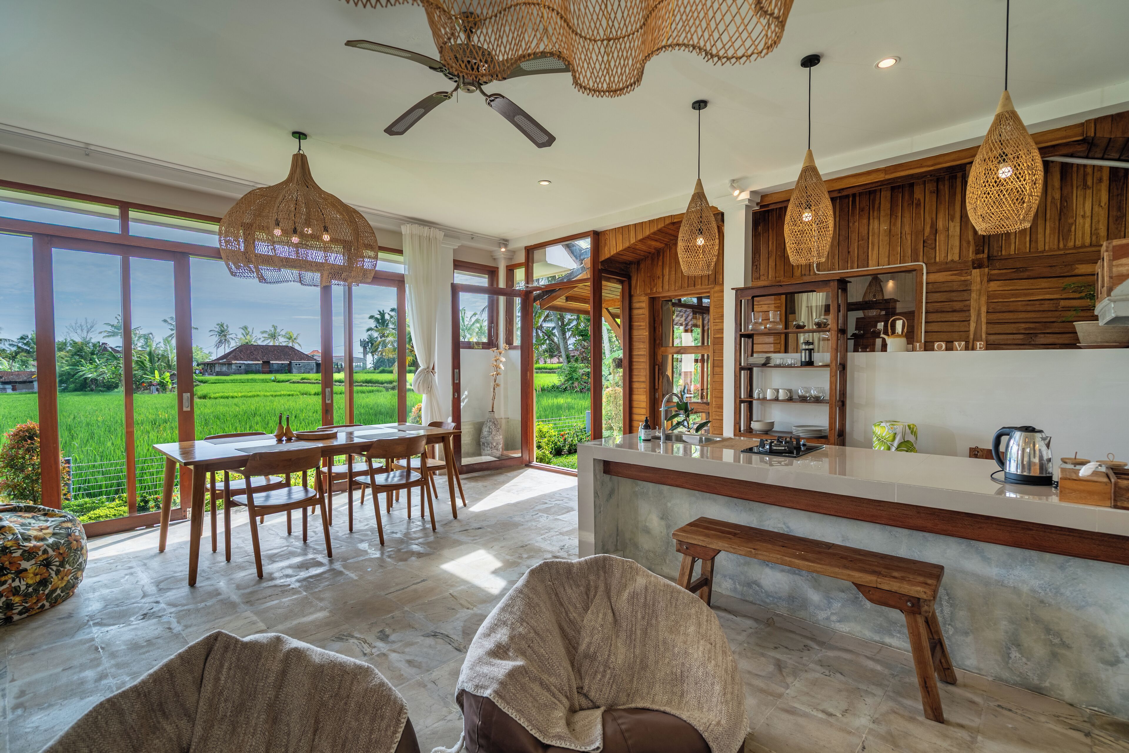 Una cocina amplia con una isla grande, armarios de madera y vistas a un paisaje verde exuberante.