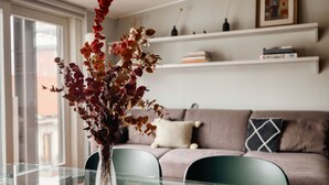 A dining area with a glass table, chairs, and a vase with dried flowers. - Hostmate - Milano - Burlamacchi 4 - Porta Romana  (Milano)