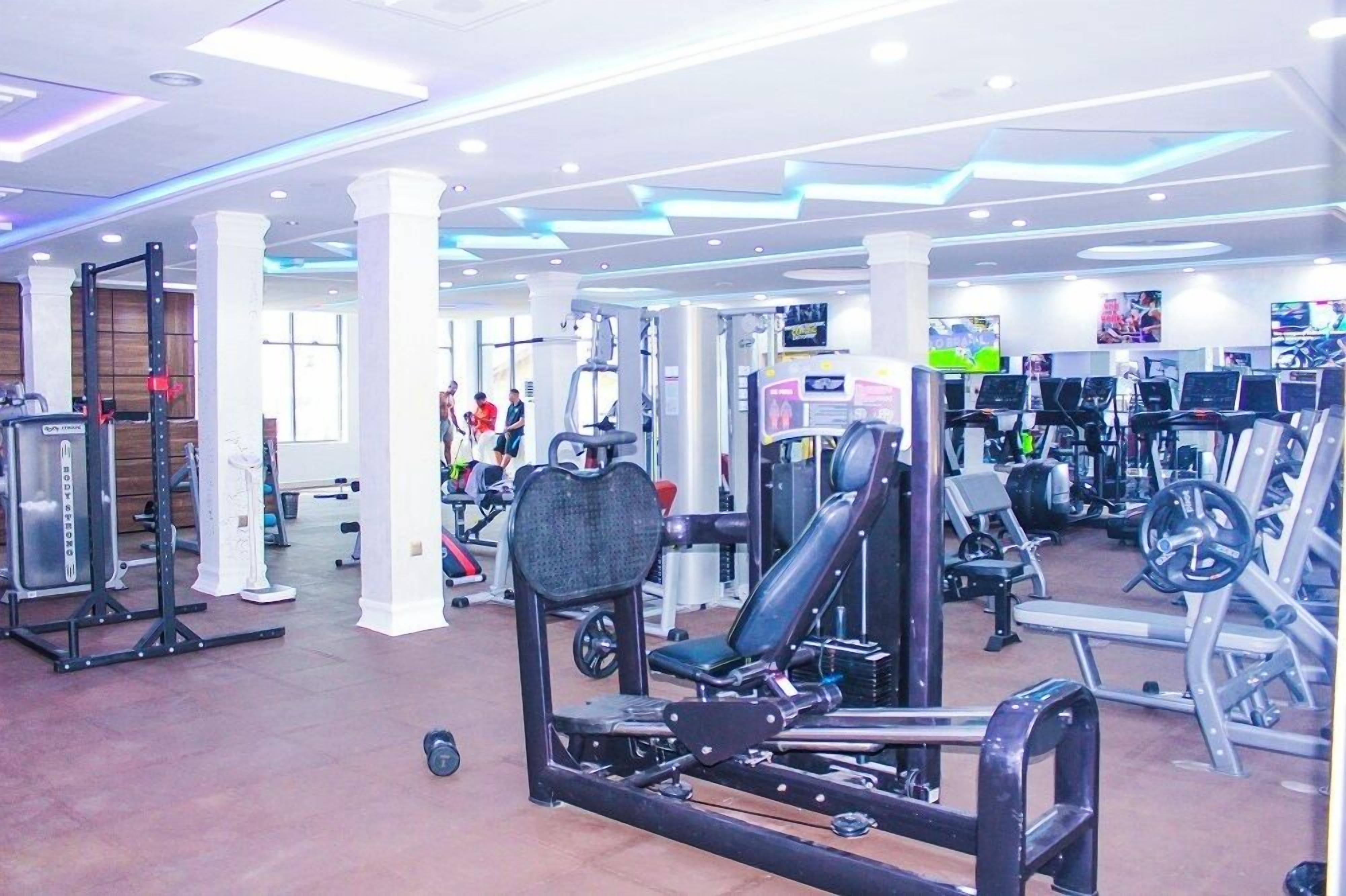 A gym with various exercise equipment, including weight machines and cardio machines.