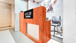 A hotel reception desk with a wooden finish and a sign that reads "HOTEL O". - Hotel O Sneh Rashmi Botanical Garden (Surat)