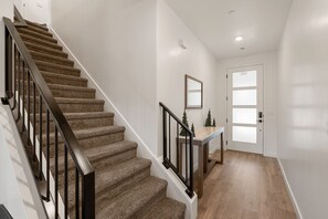 A staircase with carpeted steps and black railings, leading to a door with frosted glass panels. - Chill and Grill Getaway: Resort Pool + Pickleball (Washington)