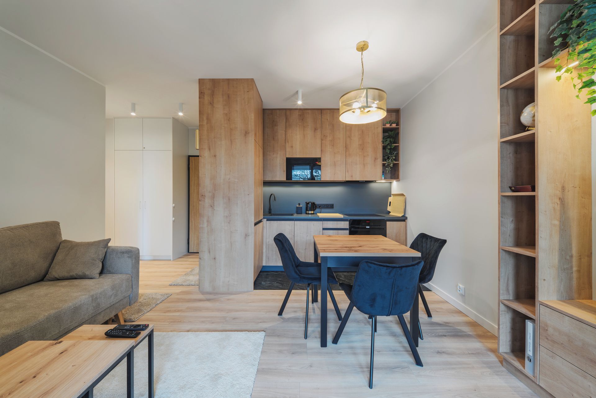 Una cocina moderna con armarios de madera, una mesa de comedor con sillas, un sofá y una mesa auxiliar.