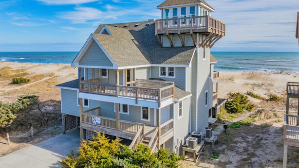 A multi-story beachfront house with a prominent tower, balconies, and a view of the ocean. - Oceanfront, Dog Friendly Home in Avon with Private Swimming Pool and Hot Tub (Avon)