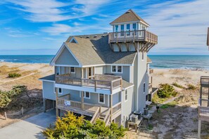A multi-story beachfront house with a prominent tower, balconies, and a view of the ocean. - Oceanfront, Dog Friendly Home in Avon with Private Swimming Pool and Hot Tub (Avon)