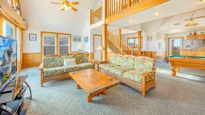 A spacious living room with a high ceiling, wooden staircase, and a pool table. - Oceanfront, Dog Friendly Home in Avon with Private Swimming Pool and Hot Tub (Avon)