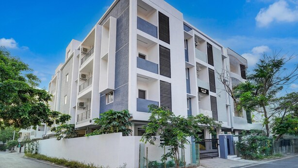A modern multi-story residential building with balconies, a gated entrance, and surrounding greenery. - Super Hotel O Valasaravakkam Metro Mall (Chennai)