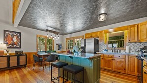 Una cocina con armarios de madera, una isla grande y una zona de comedor con sillas.