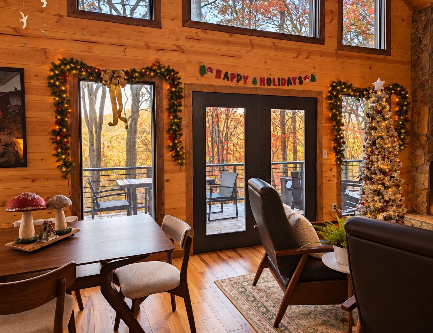 A cozy cabin interior with a dining area, a fireplace, and a view of autumn trees through large windows.