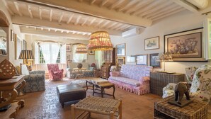 Un salon spacieux avec un plafond haut, des meubles en osier et une variété d’objets décoratifs.
