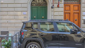 Un VUS noir était garé devant un immeuble dont les portes étaient numérotées et qui avait une porte verte.